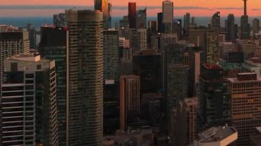 Günbatımında Toronto, Ontario, Kanada 'da modern şehir merkezi gökdelenleri ve Ontario Gölü' nün çarpıcı panoramik görüntüsü.