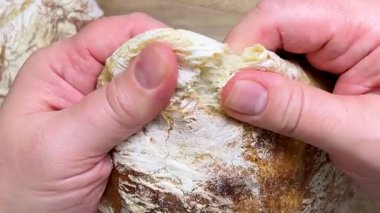 Taze pişmiş, lezzetli ev yapımı ciabatta elle ikiye bölünmüş. Ciabatta ceviz ağacından kesme tahtasında.