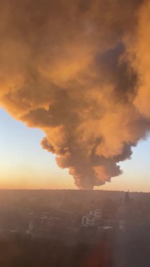 Bir Rus füzesi Ukrayna 'daki enerji altyapısını ve depoları vurduktan sonra gün doğumunda bir duman bulutu yükselir. Dikey video.