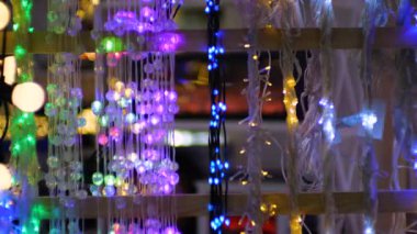 Şenlikli Noel ışıkları ve parıltılı dekorasyonlar sıcak ve büyülü bir atmosfer yaratır. Canlı mavi, mor, sarı ve beyaz LED ışıklar yumuşak odak arka planda güzel bir şekilde parıldıyor..