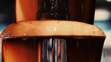 Sıcak erimiş çikolata çikolata bir çikolata çeşmesinden aşağı akar. Bu lezzetli tatlı meyve ve marşmelov daldırmak için mükemmel. Sıcak, zengin sıvı ağız sulandırıcı bir görüntü yaratır..