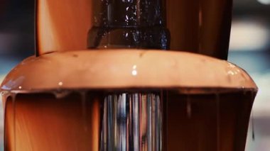 Sıcak erimiş çikolata çikolata bir çikolata çeşmesinden aşağı akar. Bu lezzetli tatlı meyve ve marşmelov daldırmak için mükemmel. Sıcak, zengin sıvı ağız sulandırıcı bir görüntü yaratır..