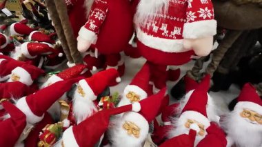 Bir alışveriş merkezinde sergilenen birçok Noel Baba oyuncağını yakından çek. Bir perakende mağazasında satılık Noel süslemeleri. Geleneksel Noel Baba figürleri için tatil sezonu alışverişi.