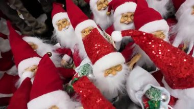 Bir alışveriş merkezinde sergilenen birçok Noel Baba oyuncağını yakından çek. Bir perakende mağazasında satılık Noel süslemeleri. Geleneksel Noel Baba figürleri için tatil sezonu alışverişi.