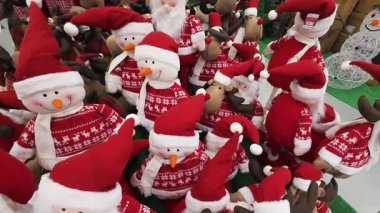 Bir alışveriş merkezinde satılık Noel süsleri. Kardan adam ve ren geyiği pelüş oyuncaklarının yer aldığı bayram gösterisi. Perakende mağazasında mevsimlik alışveriş ortamı.