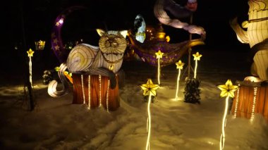 LVIV, UKRAINE - Ocak 06, 2026: Cin ve kedi fenerleri, kış gecelerinin şenlikli bir parkında ışıldıyor. Sihirli ışık figürleri büyüleyici bir atmosfer yaratır..