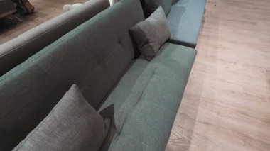 Modern bir mobilya galerisinde rahat, gri bir kanepe. Modern yaşam alanları için şık ev dekorasyonu ilham kaynağı. Ev dekorasyonu için rahat ve çağdaş mobilyalar.