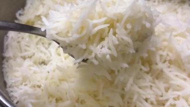 Taze pişmiş beyaz basmati pilavı tencerede pişiyor. Sıcak, kabarık tanecikleri yakından çek, yemek için mükemmel..
