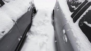 Bir kış otoparkında derin kar arabaları kaplar. Şiddetli bir kar fırtınası her yerde kalın bir kar tabakası bıraktı..