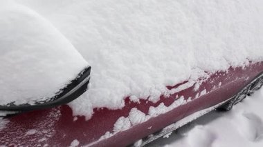 Bir araç kalın bir kar tabakasında tamamen gömülüdür. Şiddetli bir kar fırtınasından sonra bir araba park yerinde hareketsiz kaldı.