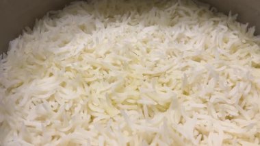 Taze pişmiş beyaz basmati pilavı tencerede pişiyor. Sıcak, kabarık tanecikleri yakından çek, yemek için mükemmel..