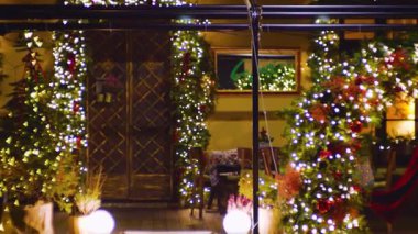 Şenlikli Noel süslemeleri büyüleyici restoran girişini süslüyor. Parlayan ışıklar ve daima yeşil ağaçlar sıcak, davetkar bir tatil ortamı yaratır..