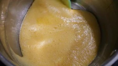 Kavanozda karamel hazırlığı. Karışık altın sıvı şeker. Güzel pişirme süreci. Kalın, tatlı karışımı karıştıran bir spatula..