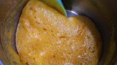 Kavanozda karamel hazırlığı. Karışık altın sıvı şeker. Güzel pişirme süreci. Kalın, tatlı karışımı karıştıran bir spatula..