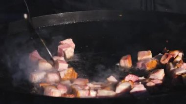 Sıcak bir tava ve yağda sosis ve et cızırdıyor. Buhar yükselirken yemek pişirme işlemini yakından çek. Sokak yemekleri hazırlanıyor..