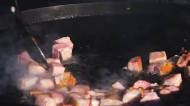 Sıcak bir tava ve yağda sosis ve et cızırdıyor. Buhar yükselirken yemek pişirme işlemini yakından çek. Sokak yemekleri hazırlanıyor..