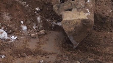 Bir kazıcı bir inşaat sahasında kazı çalışması yapıyor. Kışın film çekmek.