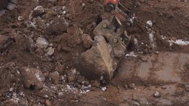 Bir kazıcı bir inşaat sahasında kazı çalışması yapıyor. Kışın film çekmek.