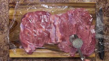 Hindi butunu ruloya hazırlıyorum. Eti metal bir çekiçle yapışkan filmle dövüyor..