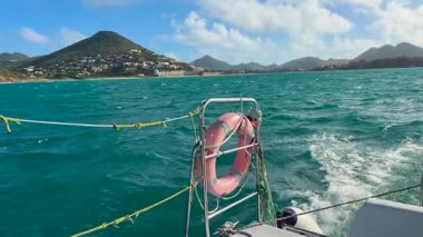 Karayip Denizi 'nde, Karayipler' in kuzeydoğusundaki Saint Martin adası yakınlarında bir tekne gezisi. Adanın kayalık kıyıları ve gemi dalgaları görünüyor..