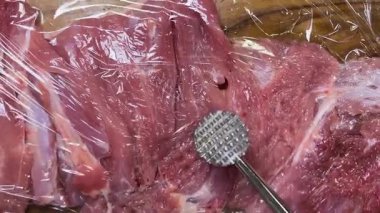 Hindi butunu ruloya hazırlıyorum. Eti metal bir çekiçle yapışkan filmle dövüyor..