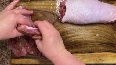 Hindi butunu ruloya hazırlıyorum. Süreç: hazırlanmış eti ahşap bir tahtanın üzerinde baharatlarla elle sarmak.