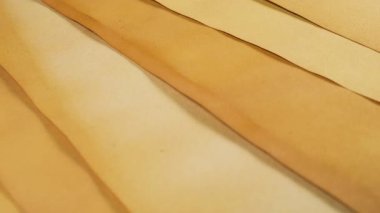 Doğal bitki bazlı pigmentlerle boyanmış el yapımı geri dönüşümlü kağıt. Sıcak toprak, siena ve sepia tonlarında eski el işi çarşaflar, dokulu bir grunge arkaplan oluşturur. Hurda günlük ve DIY yaratıcılığı için yaşlandırılmış parşömenin soyut yakın plan görüntüsü.