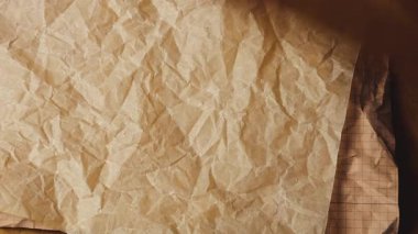 Sıcak kahverengi, terakotta ve toprak tonları ile buruşmuş el işi kağıtları teker teker katmanlanıyor. Bu dokulu arka plan, eko-dostu geri dönüşümlü materyalleri klasik parşömen estetiğiyle sergiliyor. Özet yakın plan özetleri.