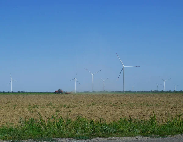 Wind farm or wind park, with high wind turbines for generation electricity. Green energy concept.