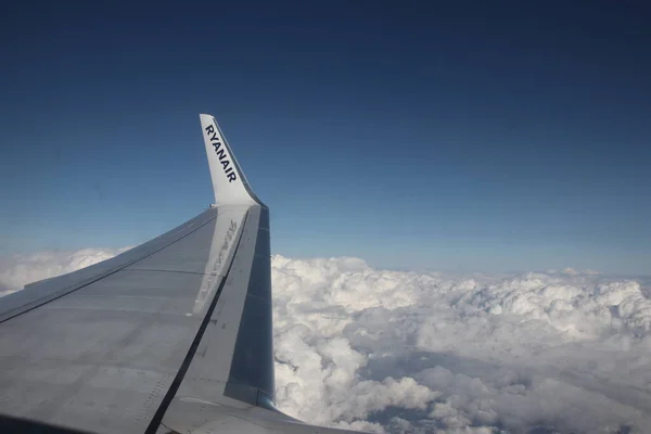 Berlin 'den Malta' ya - 19 Ekim 2020: bulutların üzerinde uçan Ryanair uçağının kanadında logo