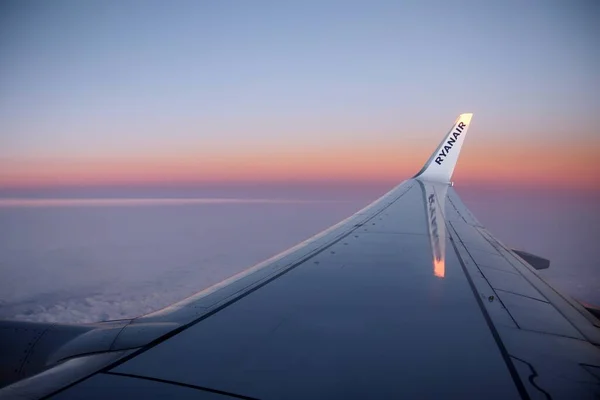Berlin 'den Malta' ya - 19 Ekim 2020: bulutların üzerinde uçan Ryanair uçağının kanadında logo