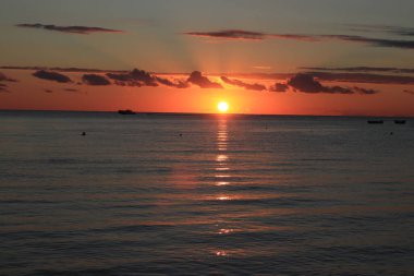 Denizin üzerinde inanılmaz bir kızıl güneş. Malta sahilinden gün batımı görüldü.