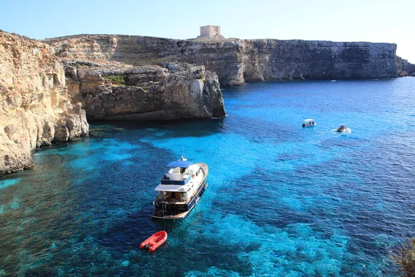 Comino Adası, Malta - 20 Ekim 2020: Turistli tekneler, Kristal lagünündeki kayadan manzara.