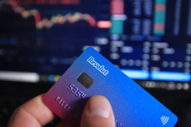 Berlin, Almanya - 21 Nisan 2021: Revolut bankamatik kartını elinde tutan adam. Revolut hızlı, basit ve kolay bir satın alma, satma ve kripto para tutma yoludur..