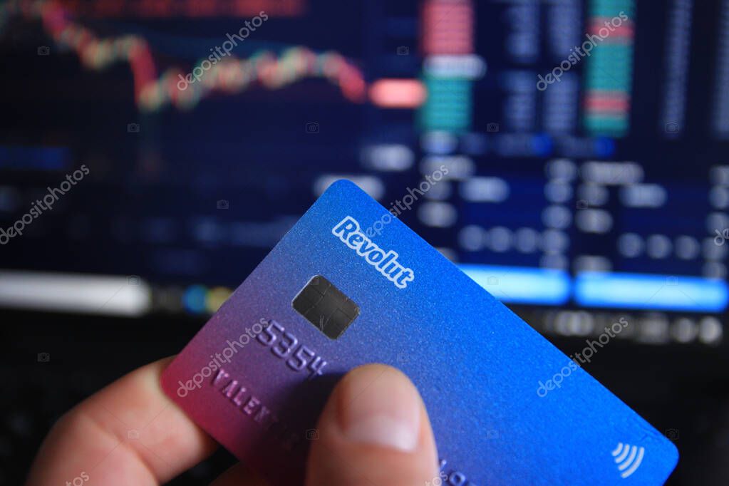 Berlin, Germany - April 21, 2021: Man holding Revolut debit card in hand. Revolut is a fast, simple, and easy way to buy, sell, and hold cryptocurrencies.