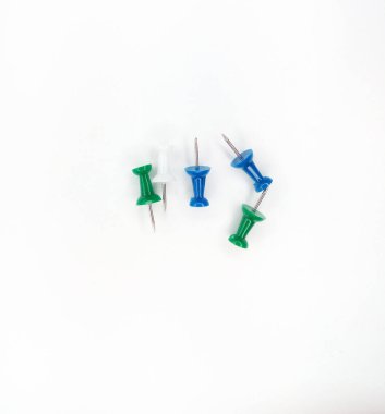 Beyaz arka planda izole edilmiş raptiyeler. Ofis kırtasiyesi yeşil ve mavi renk.