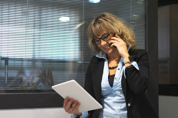 blonde business woman working in the office and talking on the phone