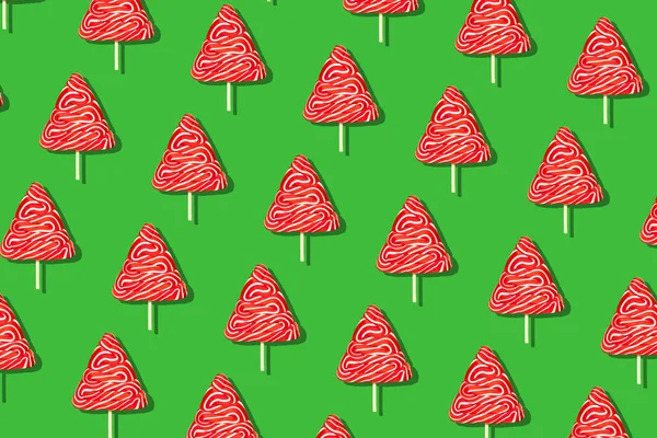 Seamless christmas pattern from sweet tree on green background.