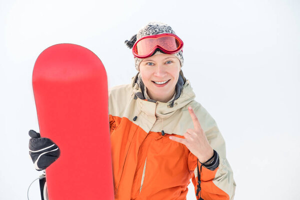 Portrait of a woman snowboarder in goggles on the background of a snowy slope.