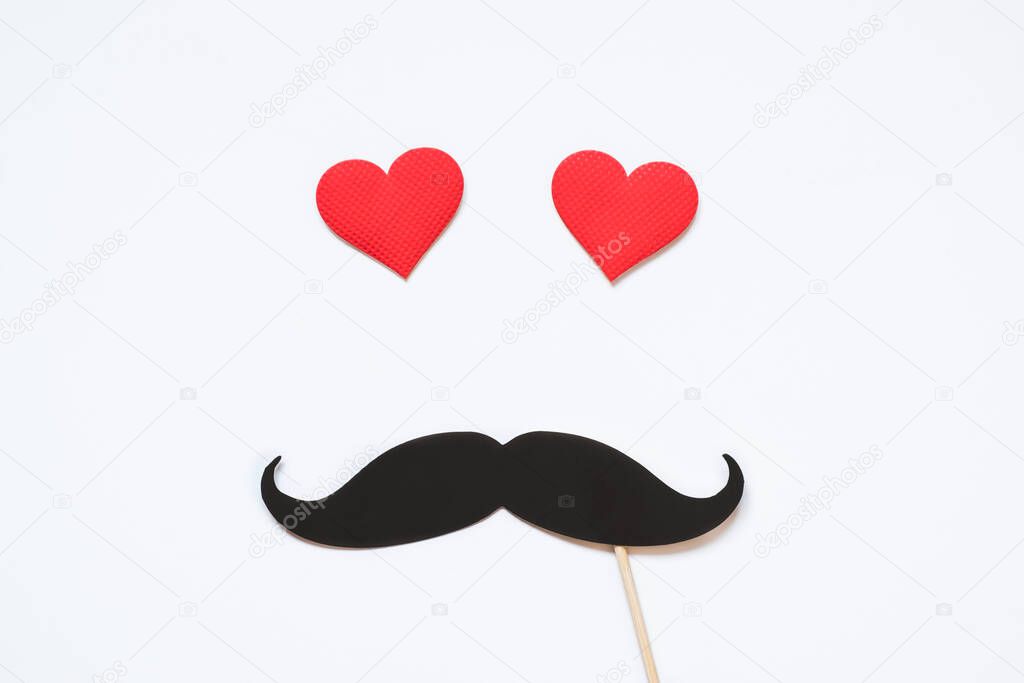 Valentine's day, love, romantic concept. Red hearts with mustaches paper prop on red background.