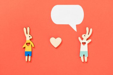 Sevgililer Günü lgbt, aşk, romantik konsept. Bir çift tavşan, bir çocuk ve kırmızı arka planda kalpleri olan bir çocuk. Düz konum, üst görünüm, kopyalama alanı.