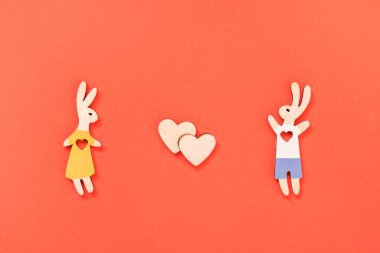Sevgililer günü, aşk, romantik konsept. Bir çift tavşan, bir kız ve beyaz arka planda kırmızı kalpli bir oğlan. Düz yatış, üst görünüm.