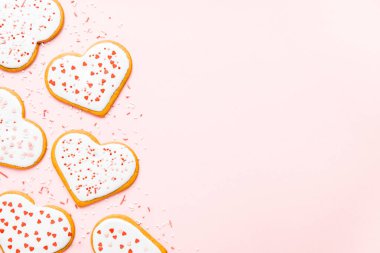 Sevgililer günü için ev yapımı kurabiyeler pembe arka planda fotokopi alanı serpiştirilmiş kalpler.