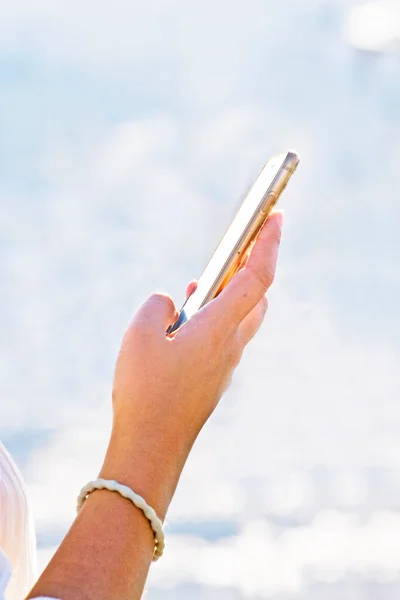 taking pictures on a smartphone, a hand on a light background holds a smartphone