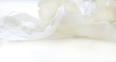 wrinkled white napkin on a white table, elongated format