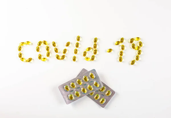 covid -19 beyaz bir zemin üzerinde bir kabarcık içinde tablet ambalajı ile D vitamini içeren kapsüller şeklinde serildi