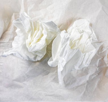 Buruşmuş beyaz peçeteler buruşmuş masa peçetesinin üzerinde uzamış.