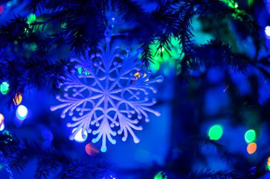 Mavi kar taneleri gece bir Noel ağacında fenerli mavi ışık, yatay format