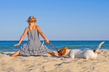 Mutlu Jack Russell Terrier ve deniz kenarında küçük bir kız.