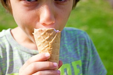 Çocuk doğada waffle bardağında dondurma yiyor.